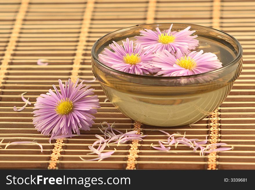 Bowl with flowers on a wooden napkin