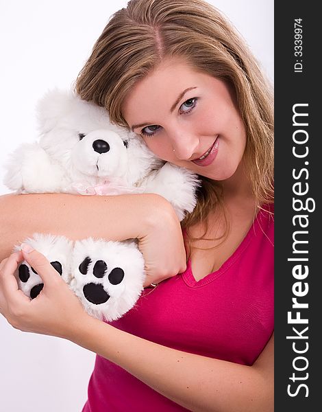 Young adult woman snuggles her white stuffed animal with a friendly face. Young adult woman snuggles her white stuffed animal with a friendly face.