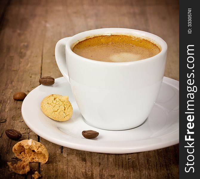 Espresso on wooden table with amarettini