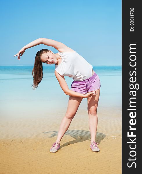 Attractive young woman doing exercise on the Beach. Attractive young woman doing exercise on the Beach