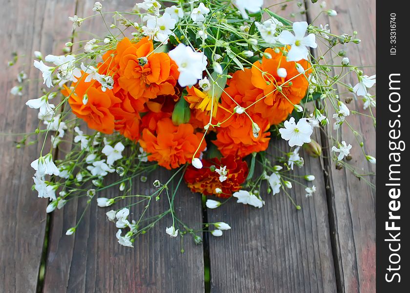 Tagetes and gypsophila flowers on the wooden table. Tagetes and gypsophila flowers on the wooden table