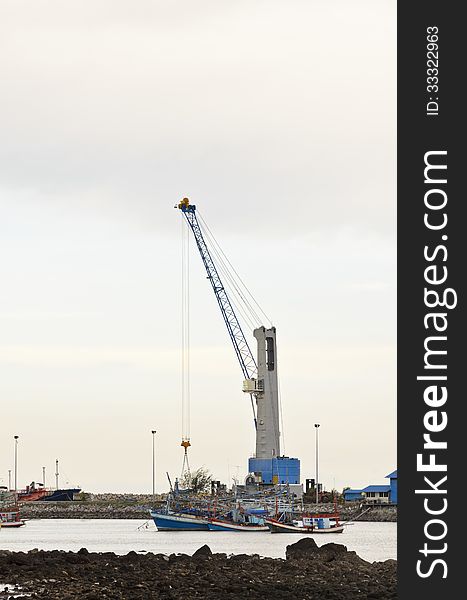 Crane for lifting a load up and down the ship. In deep water harbor area of Thailand. Crane for lifting a load up and down the ship. In deep water harbor area of Thailand