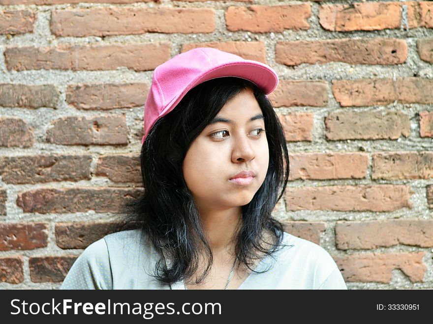 Pretentious asian girl over brick wall. Pretentious asian girl over brick wall