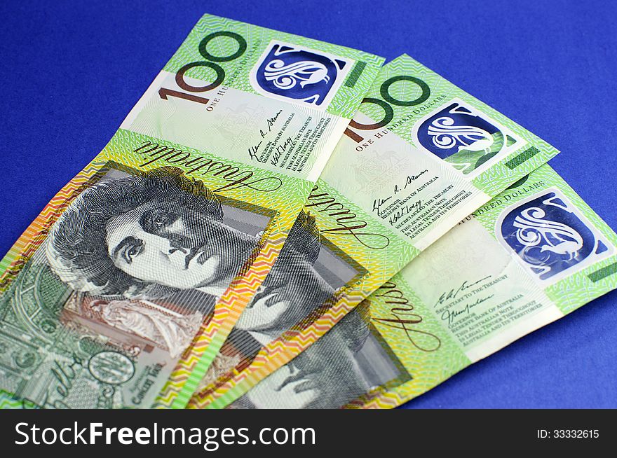 Three hundred Australian green and yellow notes on blue background. Three hundred Australian green and yellow notes on blue background.