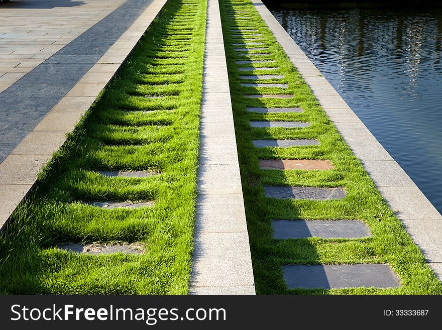 Flagstone path with green grass by lake. Flagstone path with green grass by lake
