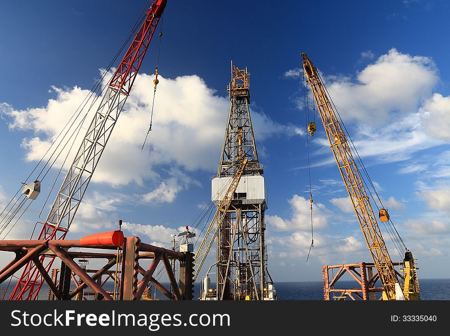 Jack Up Offshore Drilling Rig With Rig Cranes on Sunny Day in The Middle of Ocean