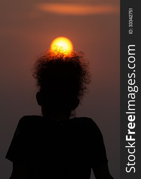 Silhouette of a man with golden sun rise on his afro hair