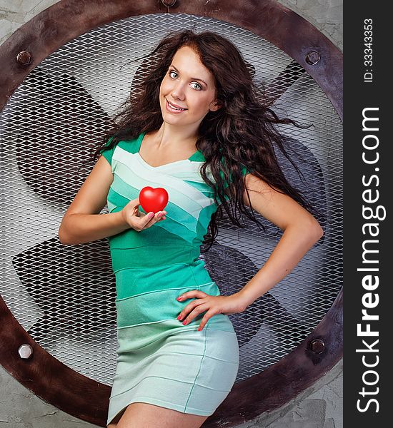 Beautiful girl in a dress holding a heart, photographed in the studio. Beautiful girl in a dress holding a heart, photographed in the studio