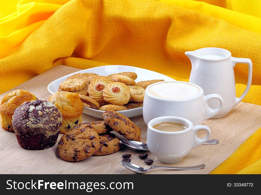 Breakfast with muffins, cookies and milk and coffee