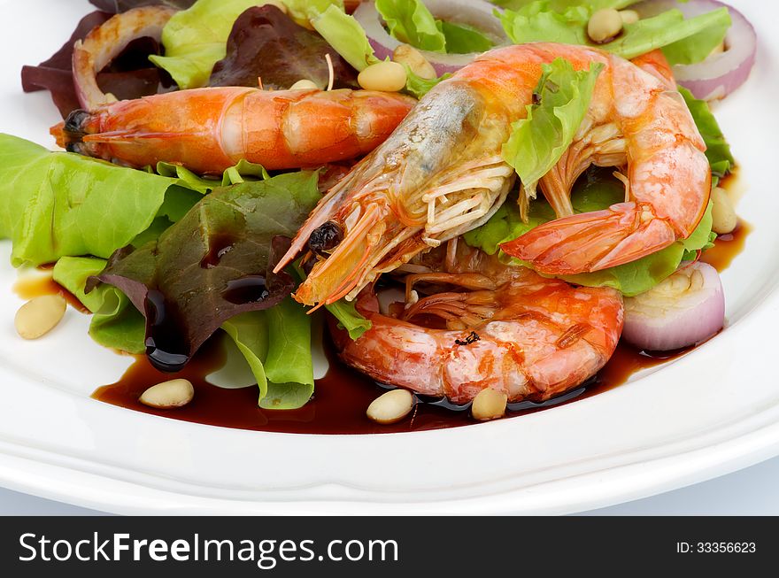 Delicious Salad with Fried Prawns, Mix Fresh Greens and Soy Sauce closeup on White plate. Delicious Salad with Fried Prawns, Mix Fresh Greens and Soy Sauce closeup on White plate