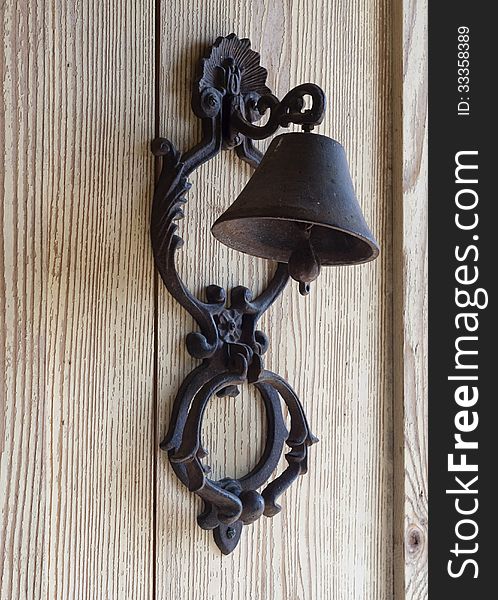 Iron bell hanging on a wooden wall