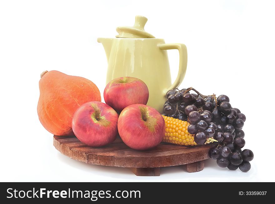 Autumn colorful fruits placed on wooden plank with a jug. Autumn colorful fruits placed on wooden plank with a jug