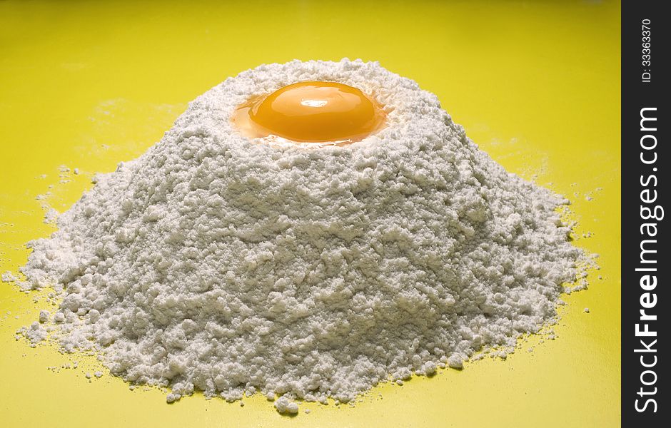 Wheat flour with egg on a yellow background. Wheat flour with egg on a yellow background