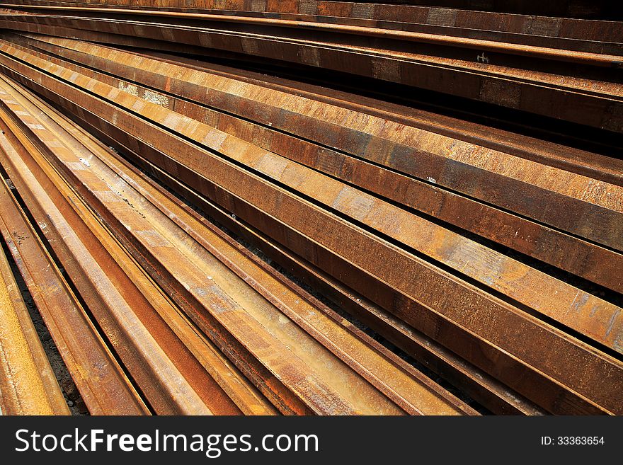 A pile rusty steel rails background. A pile rusty steel rails background