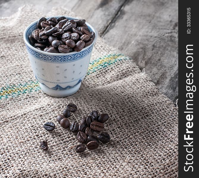 Blue coffee cup filled with coffee beans,