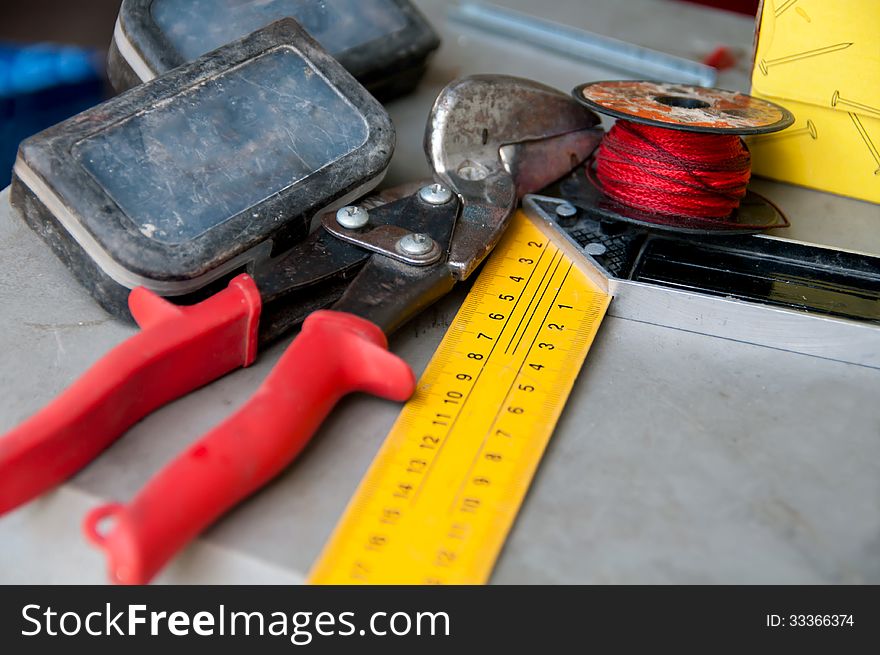 Cutters and angular ruler,a spool of thread are on the table