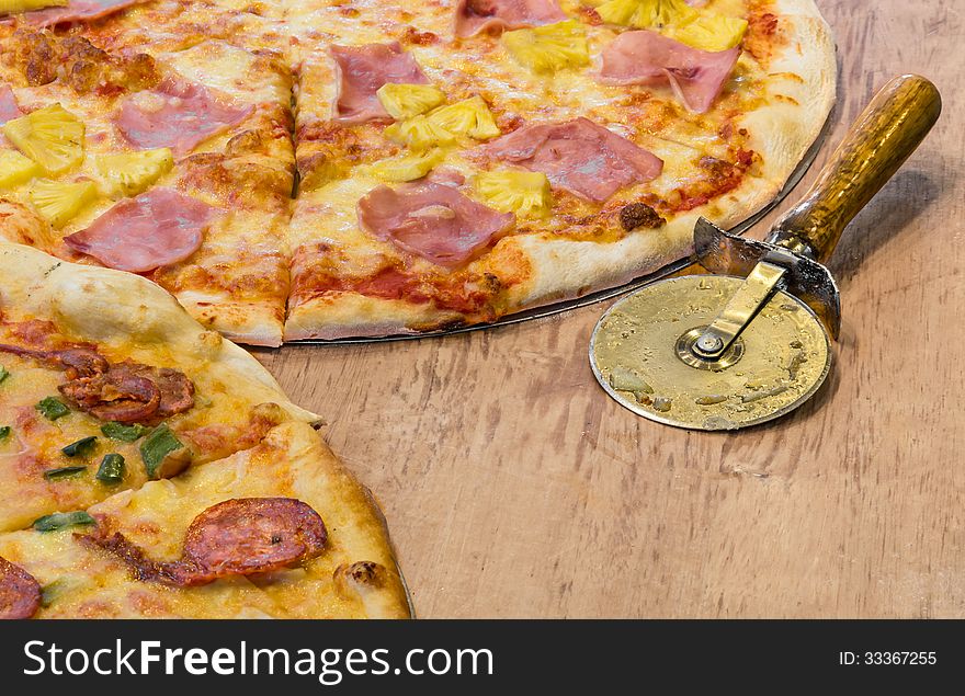 Detail of a pizzeria desk with a part of Hawaii pizza. Detail of a pizzeria desk with a part of Hawaii pizza.