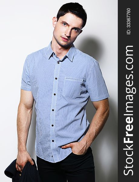 Fashionable Male in Blue Shirt standing in studio. Fashionable Male in Blue Shirt standing in studio