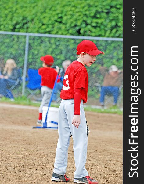 A young child playing Little League baseball and getting directions from his coach in a game played in June 2013 and Oregon. A young child playing Little League baseball and getting directions from his coach in a game played in June 2013 and Oregon.