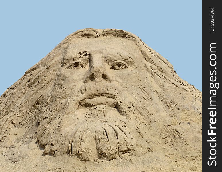 Face carved in a pile of sand against a blue sky, a depiction of Christ. Face carved in a pile of sand against a blue sky, a depiction of Christ.