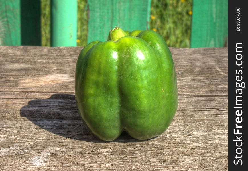 Big green pepper bell on old wooden background. Big green pepper bell on old wooden background.