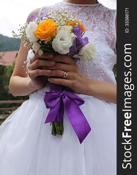 Bride holding near her body the wedding bridal bouquet.