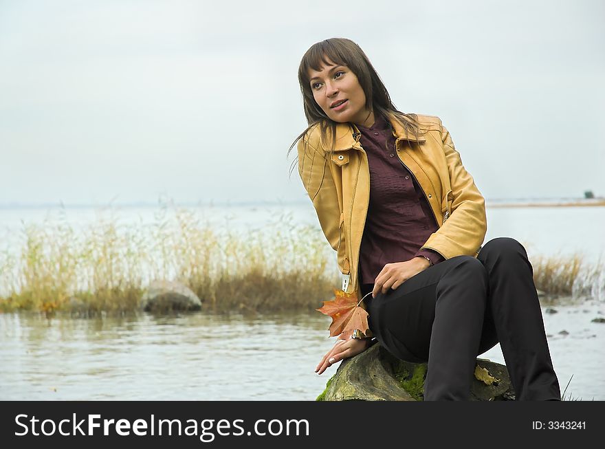 The beautiful girl on coast of a reservoir