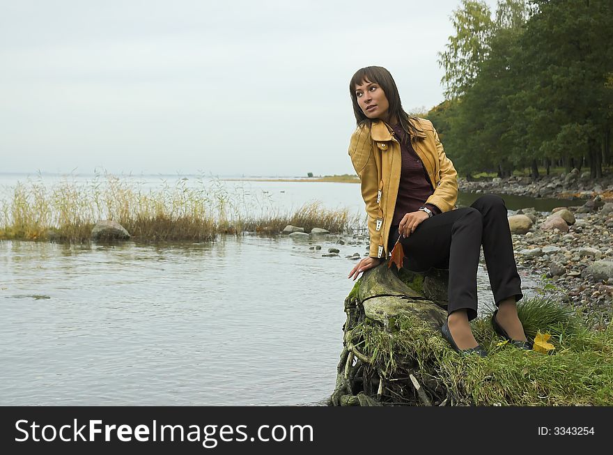 The beautiful girl on coast of a reservoir