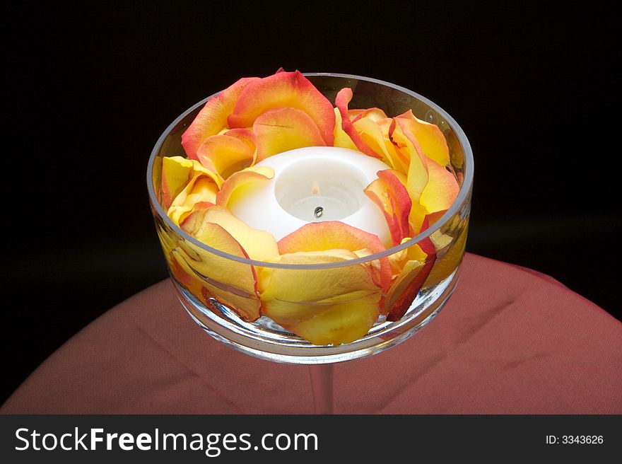 An image of a beautiful votive candle holder with rose petals. An image of a beautiful votive candle holder with rose petals