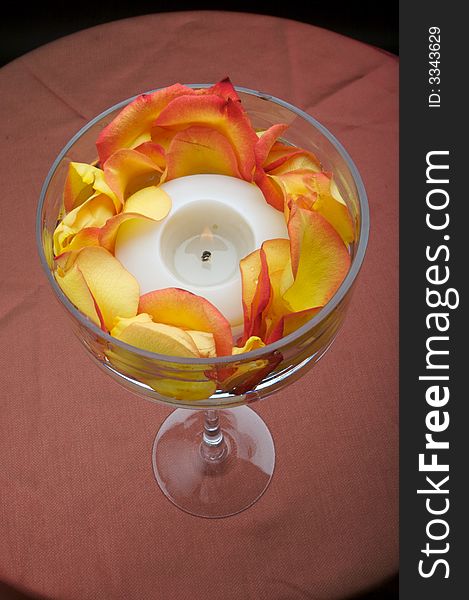 An image of a beautiful votive candle holder with rose petals. An image of a beautiful votive candle holder with rose petals