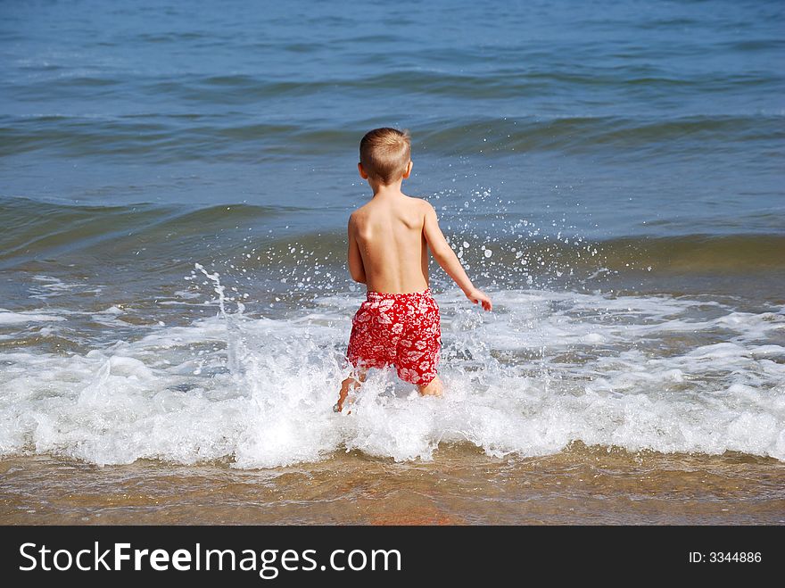 Boy splashing in the waves. Boy splashing in the waves