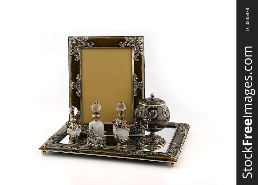 Picture frame, jewelry case and perfume bottles on mirrored tray. Picture frame, jewelry case and perfume bottles on mirrored tray
