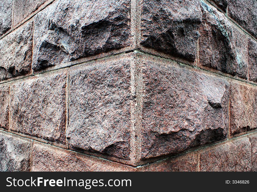 A decorative background, a corner of a wall of a building from rough stone blocks. A decorative background, a corner of a wall of a building from rough stone blocks.