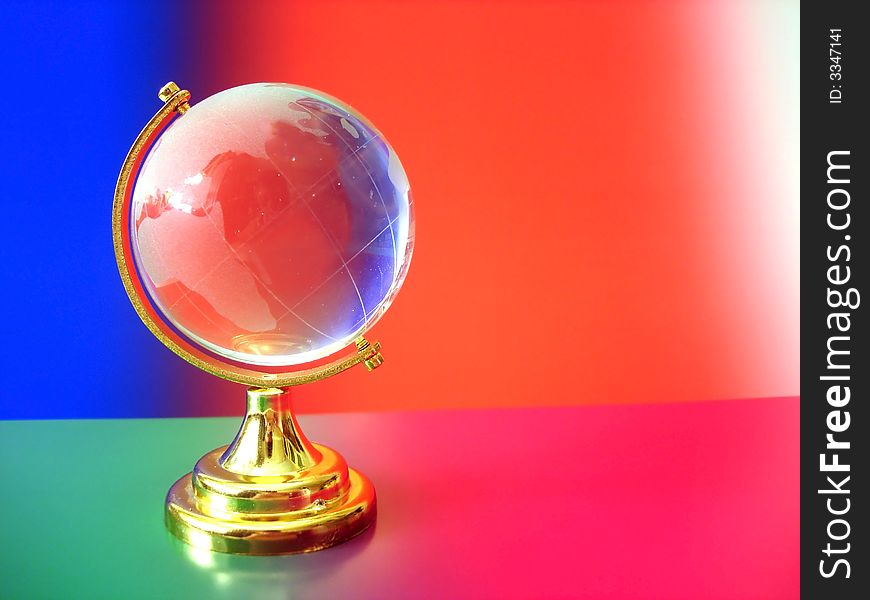 Glass globe of the world on colored background