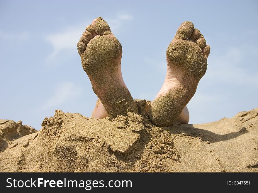 Human foots on the sand beach again the sky. Human foots on the sand beach again the sky