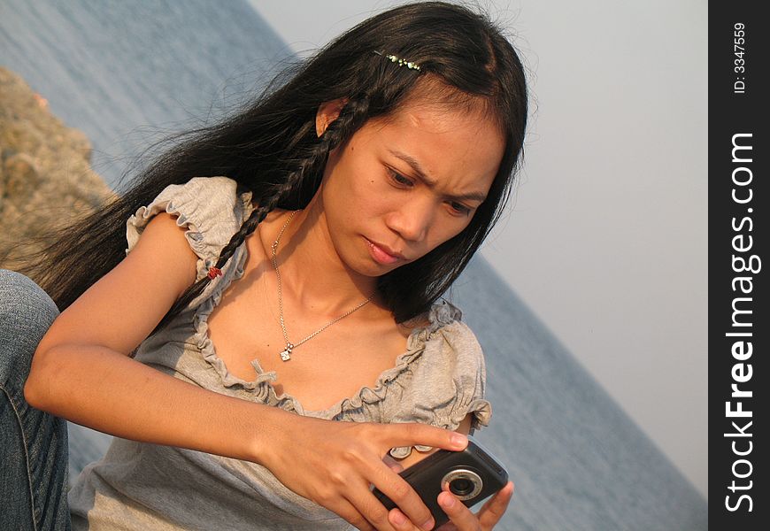 Girl on Mactan island, sending SMS home to friends. Girl on Mactan island, sending SMS home to friends