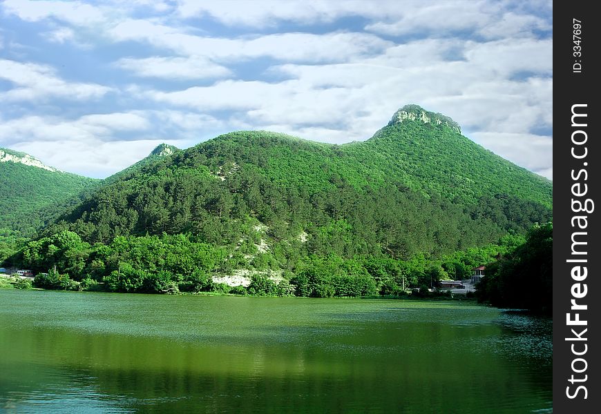 Beautiful landscape (big mountain, green lake and sky with clouds)