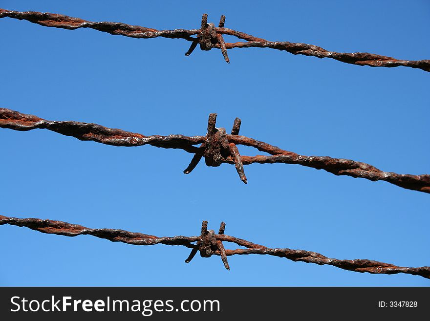 Rusty Barbed Wire against a blue sky