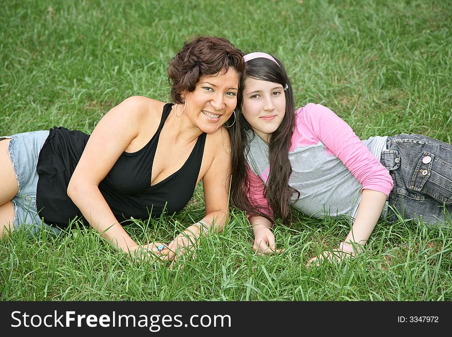 Mother and daughter-teenager lie on the grass 3