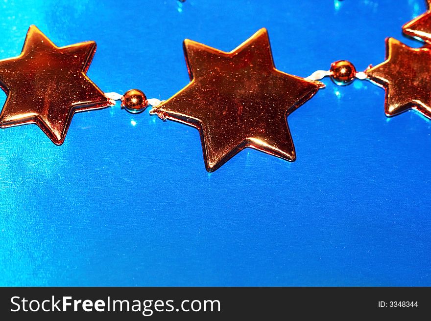 Orange Christmas stars on blue background (shallow DOF)