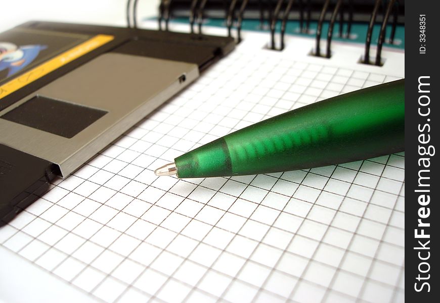 Close-up of pen and diskette on notebook