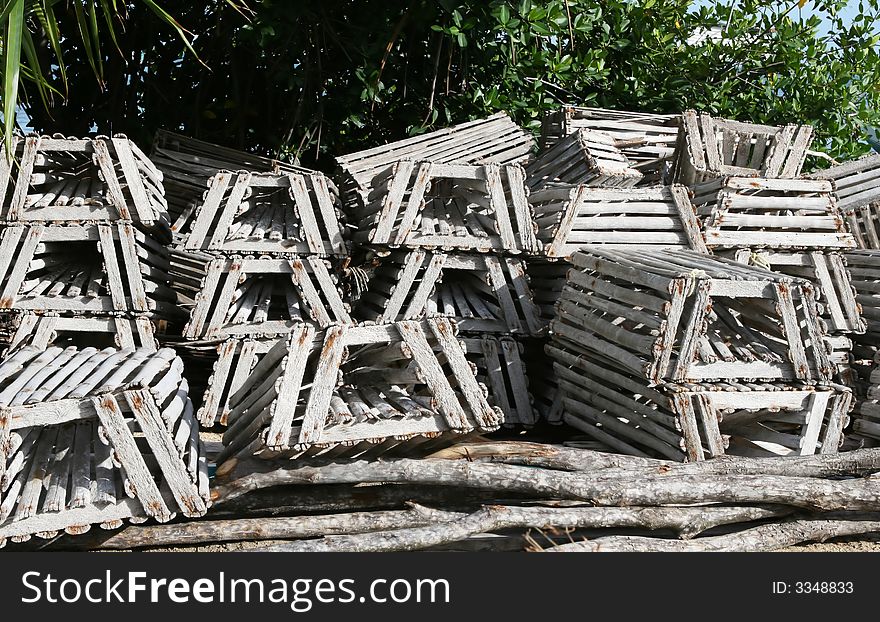 A pile of traps lie nearby the caribbean ocean. Commercial fishermen use these to trap crabs in the clear blue waters off the coast of Belize. A pile of traps lie nearby the caribbean ocean. Commercial fishermen use these to trap crabs in the clear blue waters off the coast of Belize