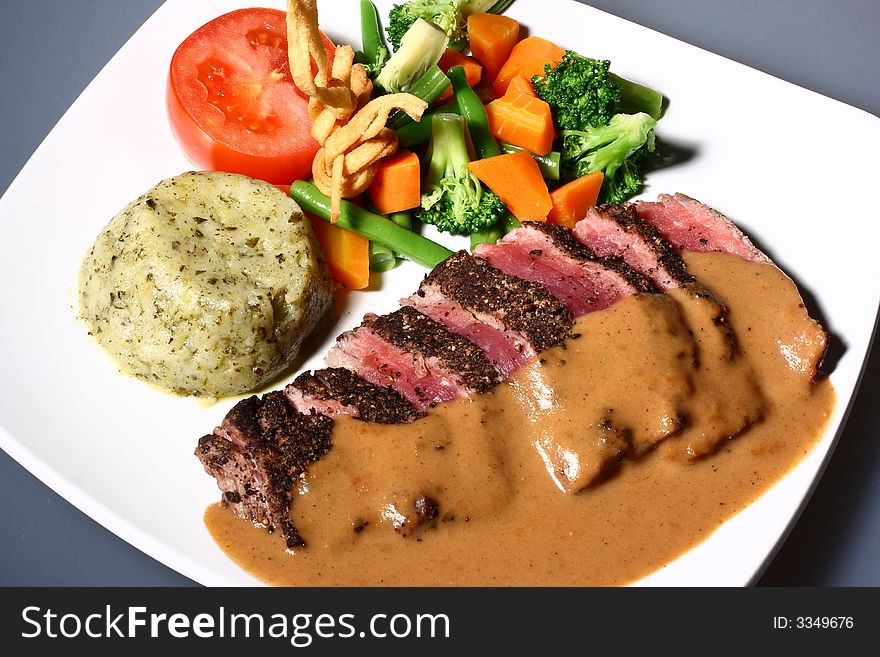 Main course consist of beef meat, vegetables, and mashed potatoes. Main course consist of beef meat, vegetables, and mashed potatoes