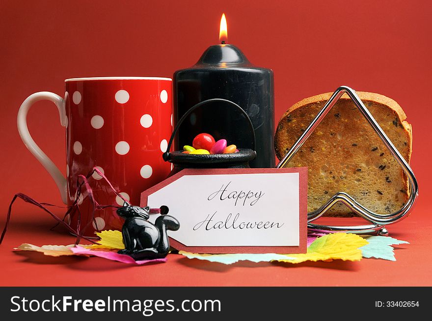 Happy Halloween morning breakfast with red polka dot coffee tea cup mug and toast with black candle and cat on autumn brown background.