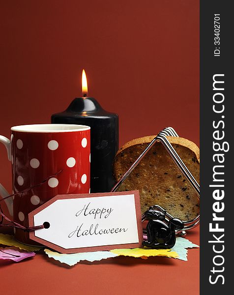 Happy Halloween morning breakfast with red polka dot coffee tea cup mug and toast with black candle and cat on autumn brown background. Happy Halloween morning breakfast with red polka dot coffee tea cup mug and toast with black candle and cat on autumn brown background.