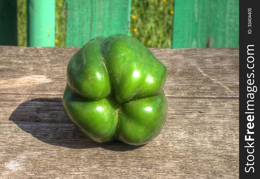Big green pepper bell on old wooden background. Big green pepper bell on old wooden background.