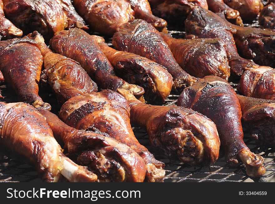 Close up of the bbq grill with a pile of turkey legs roasting and smoking to perfection. Close up of the bbq grill with a pile of turkey legs roasting and smoking to perfection