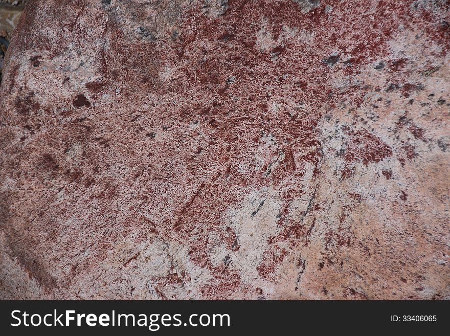 Surface of natural dark red stone (crimson quartzite porphyry) as background. Surface of natural dark red stone (crimson quartzite porphyry) as background