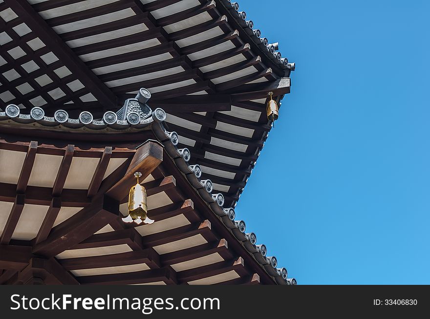 Corner View of Wooden Pagoda with Bells set against Blue Sky. Corner View of Wooden Pagoda with Bells set against Blue Sky