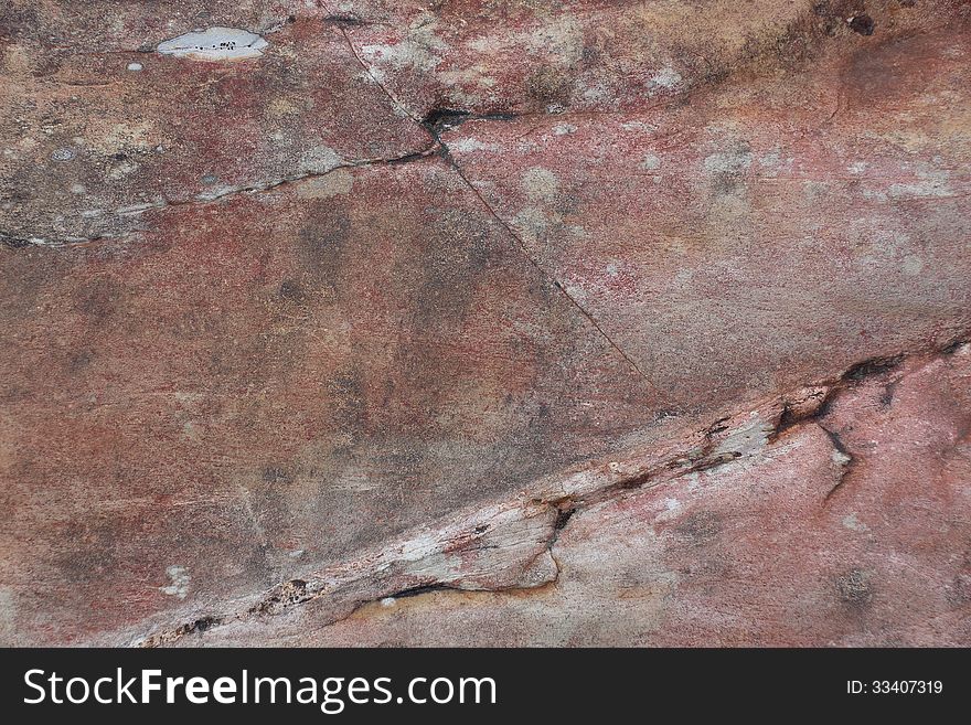 Surface of natural crack dark red stone (crimson quartzite porphyry) as background. Surface of natural crack dark red stone (crimson quartzite porphyry) as background